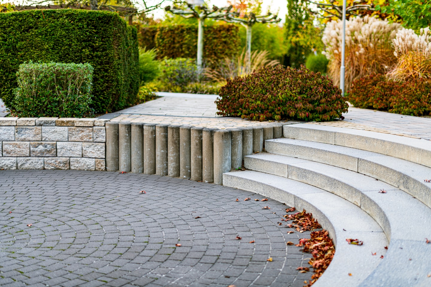 Ziegelweg, der zu Steinstufen in einem angelegten Garten führt.